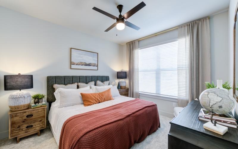 a bedroom with a bed and a fan